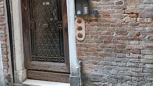 A brick building with a metal gate and a utility box.