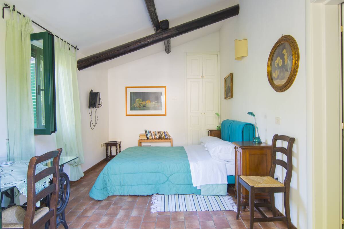 1 habitación, escritorio y tabla de planchar con plancha