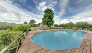 Una piscina al aire libre de temporada, sombrillas