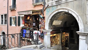 Vista de una calle con una tienda llamada 'Ezo San Marco' que exhibe diversos artículos.