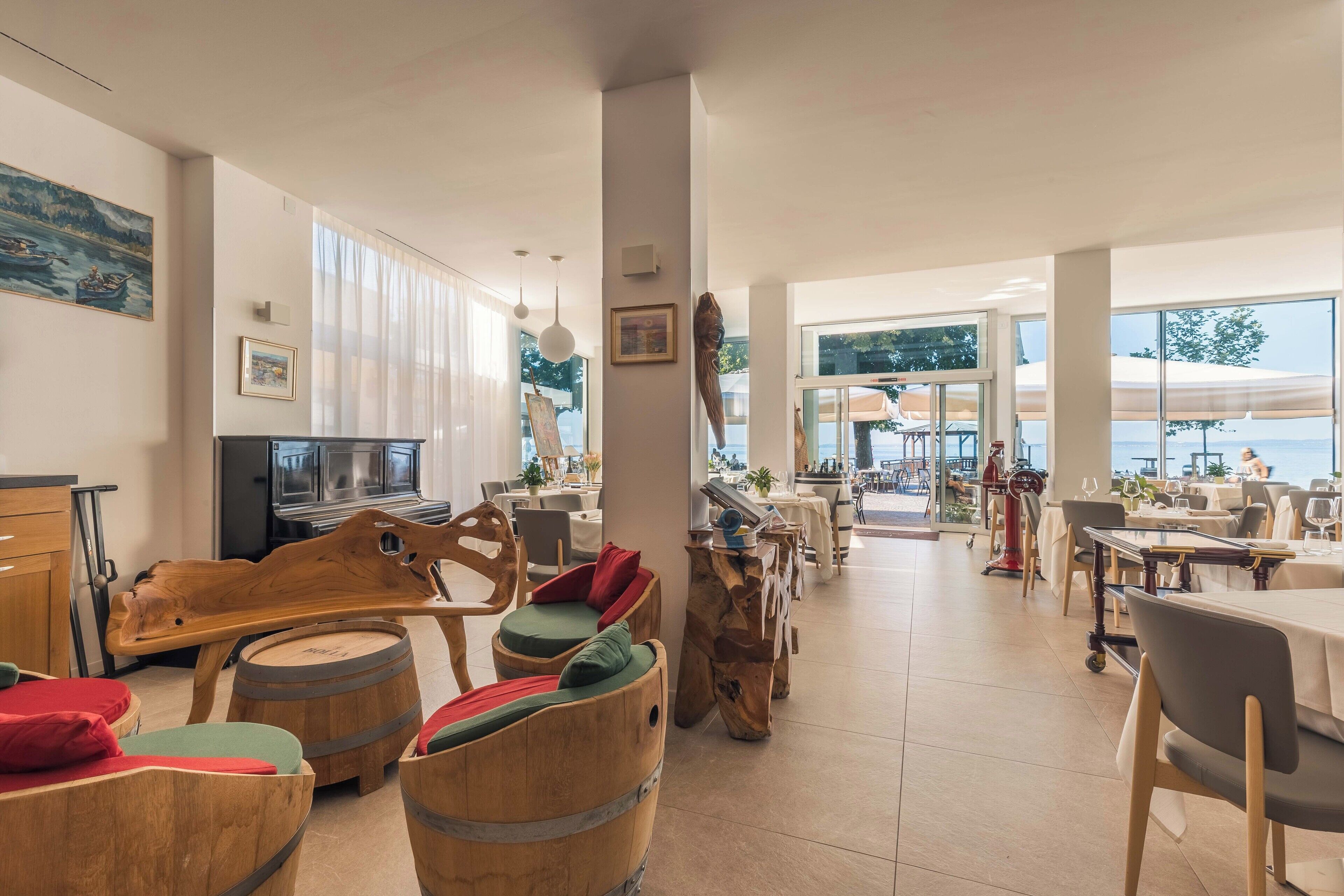 Un restaurant spacieux, doté de meubles en bois, de grandes fenêtres et offrant une vue sur la mer.