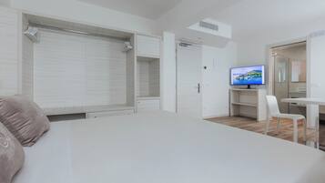 Una camera da letto con un letto, una televisione, una scrivania e una sedia.