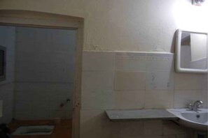 A bathroom with a sink, mirror, and shower area. - Hotel Grand Barrack (Khandwa)