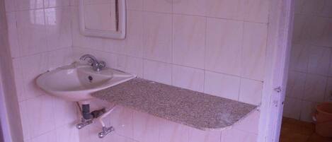 A bathroom with a white sink, a mirror, and a towel ring.