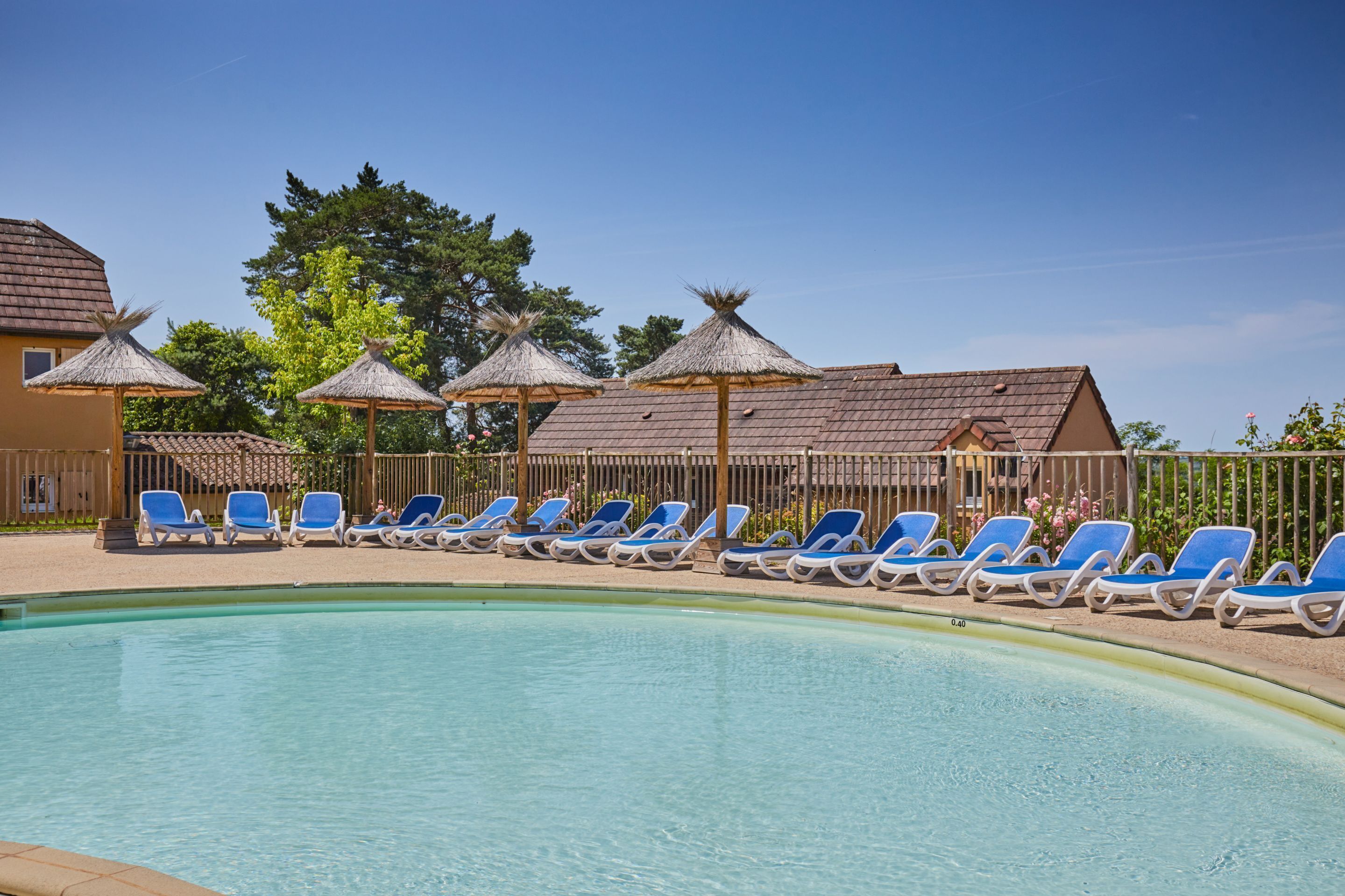Zona de piscina amb gandules blaves i sombrerets de palla.