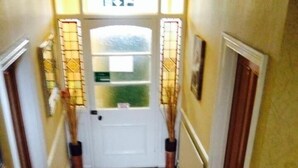 A hallway with a patterned floor, a white door, and a framed picture on the wall. - Beggar's Knap (Dorchester)
