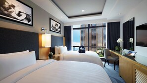 A hotel room with two beds, a desk, a chair, a TV, and a large window with a city view. - Berjaya Times Square Hotel (Kuala Lumpur)