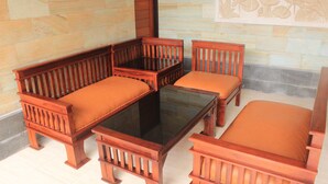 Un banco de madera con una mesa de vidrio y asientos acolchados.