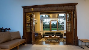An open doorway leading to a living area with a sofa, a coffee table, and a small table. - La Herencia Hotel (Armenia)