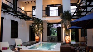 A spacious indoor area with a hot tub, lounge chairs, and potted plants. - La Herencia Hotel (Armenia)