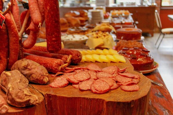 Diversos tipos de carne e queijo em uma tábua de madeira.