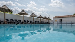 A swimming pool with lounge chairs and thatched umbrellas. - Résidence Odalys Rêve d'lle (Rivedoux-Plage)