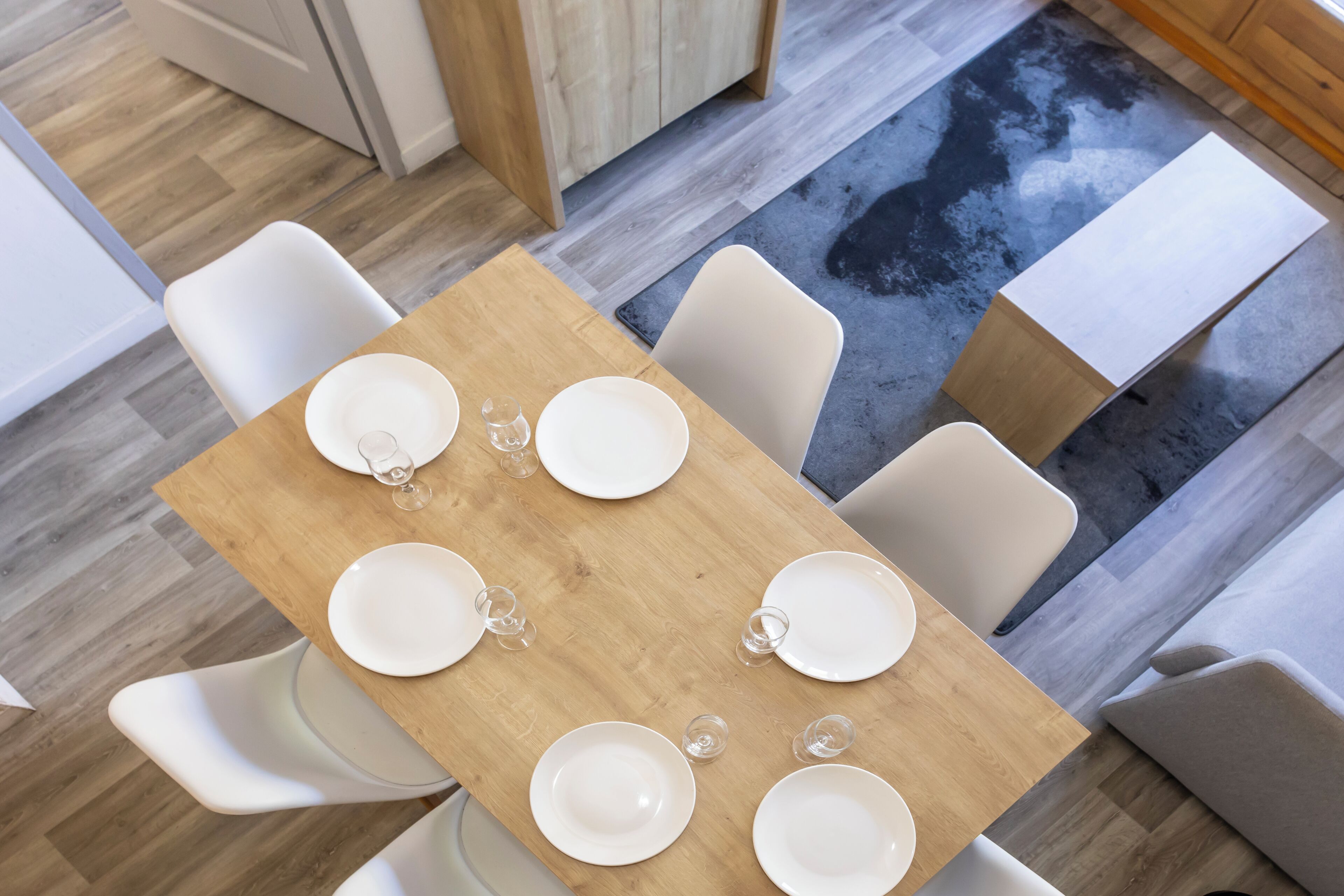 A dining area with a wooden table and white chairs.