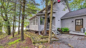 A house with a porch, stone steps, and a small garden area.