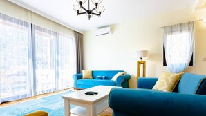 A living room with a blue sofa, a white coffee table, and a yellow armchair.