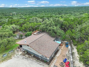 A large building with a metal roof and a deck area. - Close to town - Amazing Views - Pet Friendly house in Wimberley! (Wimberley)