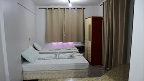 A bedroom with two beds, a wardrobe, and a window with curtains. - ADTUR CTC Condomínio Golden (Caldas Novas)