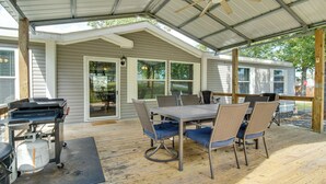 A covered patio with a table and chairs, a grill, and a propane tank. - Greers Ferry Lakefront Home w/ Deck & Boat Slips! (Greers Ferry)