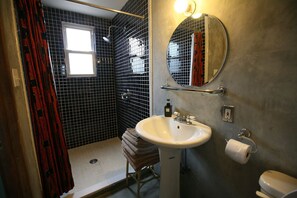 Een bad/douchecombinatie, een haardroger, handdoeken, zeep