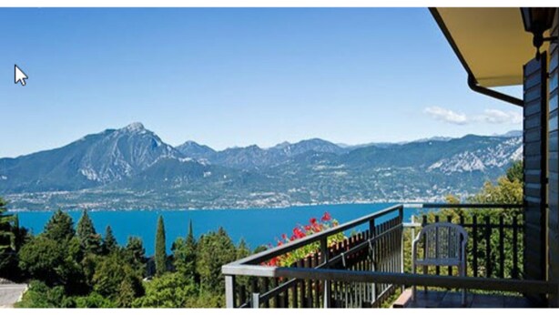 Un balcon avec vue sur un lac et des montagnes.