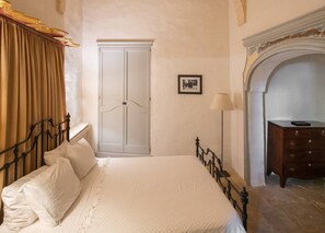 A bedroom with a bed, a wardrobe, a dresser, and a fireplace. - Luxurious Grand 18th C. Palace with Gardens & Pool (Ghaxaq)