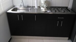 A compact kitchen with a sink, coffee maker, and stove. - Apartamento Turístico Familiar (Montenegro)