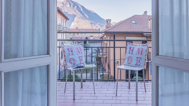 A balcony with two chairs and a view of a mountain. - Alexis House Varenna (Varenna)