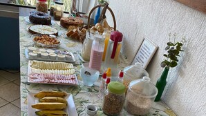 A table with various food items including fruits, pastries, and condiments. - Pousada Aldeia Buzios (Búzios)