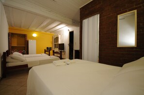 A hotel room with two beds, a brick wall, a white door, and a mirror. - Pousada Aldeia Buzios (Búzios)