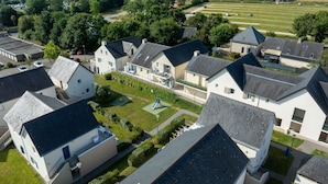 A residential area with houses, a playground, and a view of the sea. - Résidence Odalys Les Iles du Morbihan (Baden)