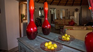 Uma sala de estar com teto rústico, um sofá e uma mesa de jantar com tigelas de frutas.
