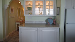 A kitchen with white cabinets, a fish-shaped decoration, and a window with glass doors. - Magnificent Ocean Front. Beautiful five-star. Perfect, quiet get-away. (Bethany Beach)