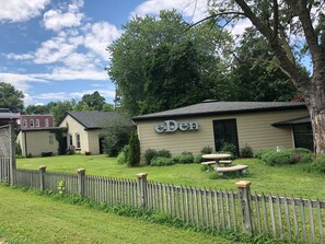 A small building with a sign reading "eden" in a grassy area with a wooden fence.