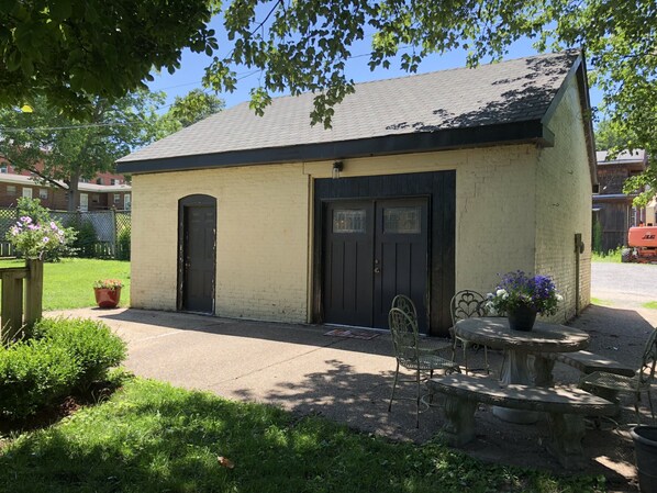 A small, single-story building with a flat roof and two black doors.