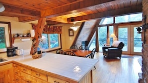 Une cuisine dotée d’un grand îlot central, de meubles en bois et d’un coin repas avec une table et des chaises.