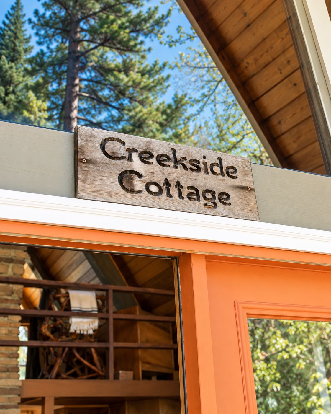 En träskylt med texten ”Creekside Cottage”, som anger namnet på fastigheten.