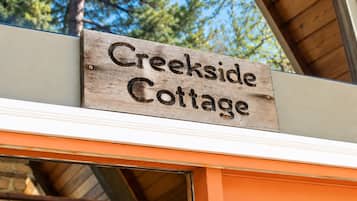 En träskylt med texten ”Creekside Cottage”, som anger namnet på fastigheten.