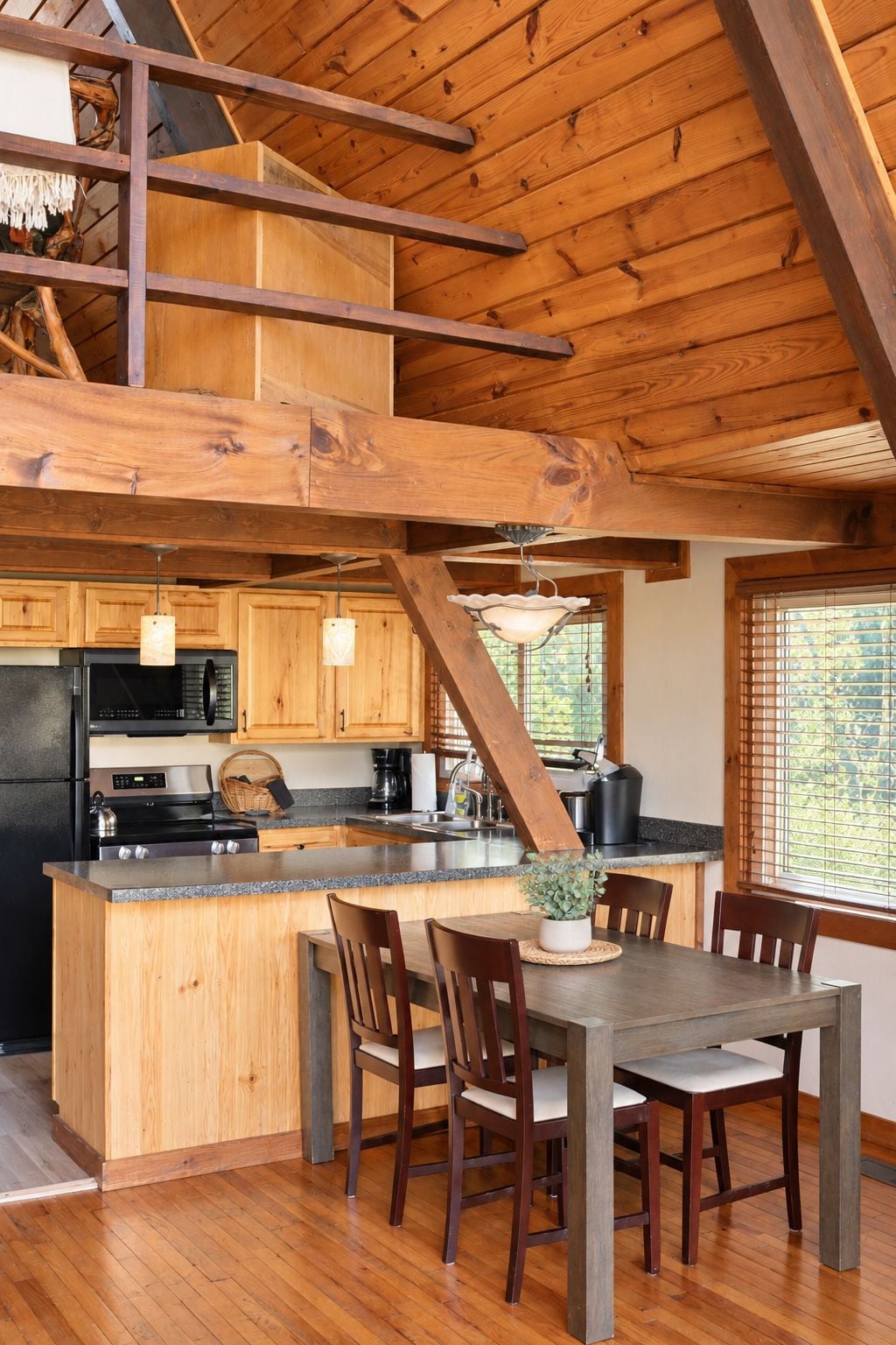 Una cocina amplia con vigas de madera, una isla central y un comedor con sillas.