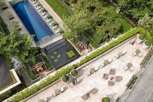 Vista aérea de un hotel con piscina, zona de estar al aire libre y abundante vegetación.