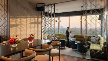 A modern interior with a dining area, a sofa, and a view of the city.