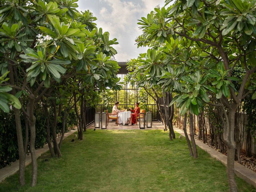A garden with a gazebo, a table, and chairs.