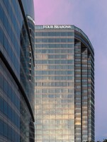 Un edificio moderno de gran altura con el nombre "FOUR SEASONS" bien visible en la parte superior.