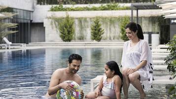 Relax by the pool in a serene, contemporary space with a clear view of the water.