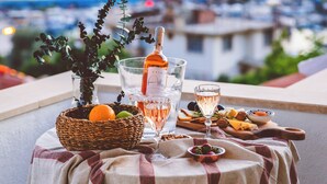 A table set with a bottle of champagne, glasses, fruits, and nuts on a balcony overlooking a body of water. - Luvi Kaş Otel - Adults Only (Kas)