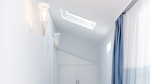 A narrow hallway with a wooden bench, white walls, a ceiling light, and a door with a white door frame. - Luvi Kaş Otel - Adults Only (Kas)