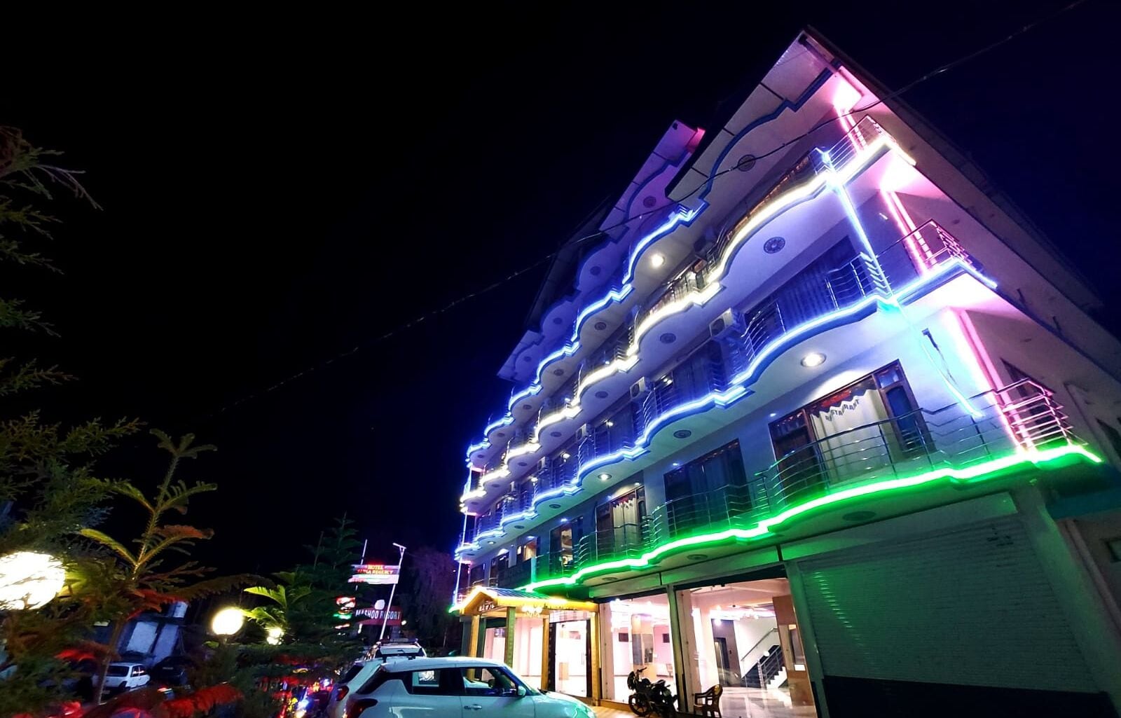 Un edificio de varios pisos con balcones y una fachada bien iluminada.