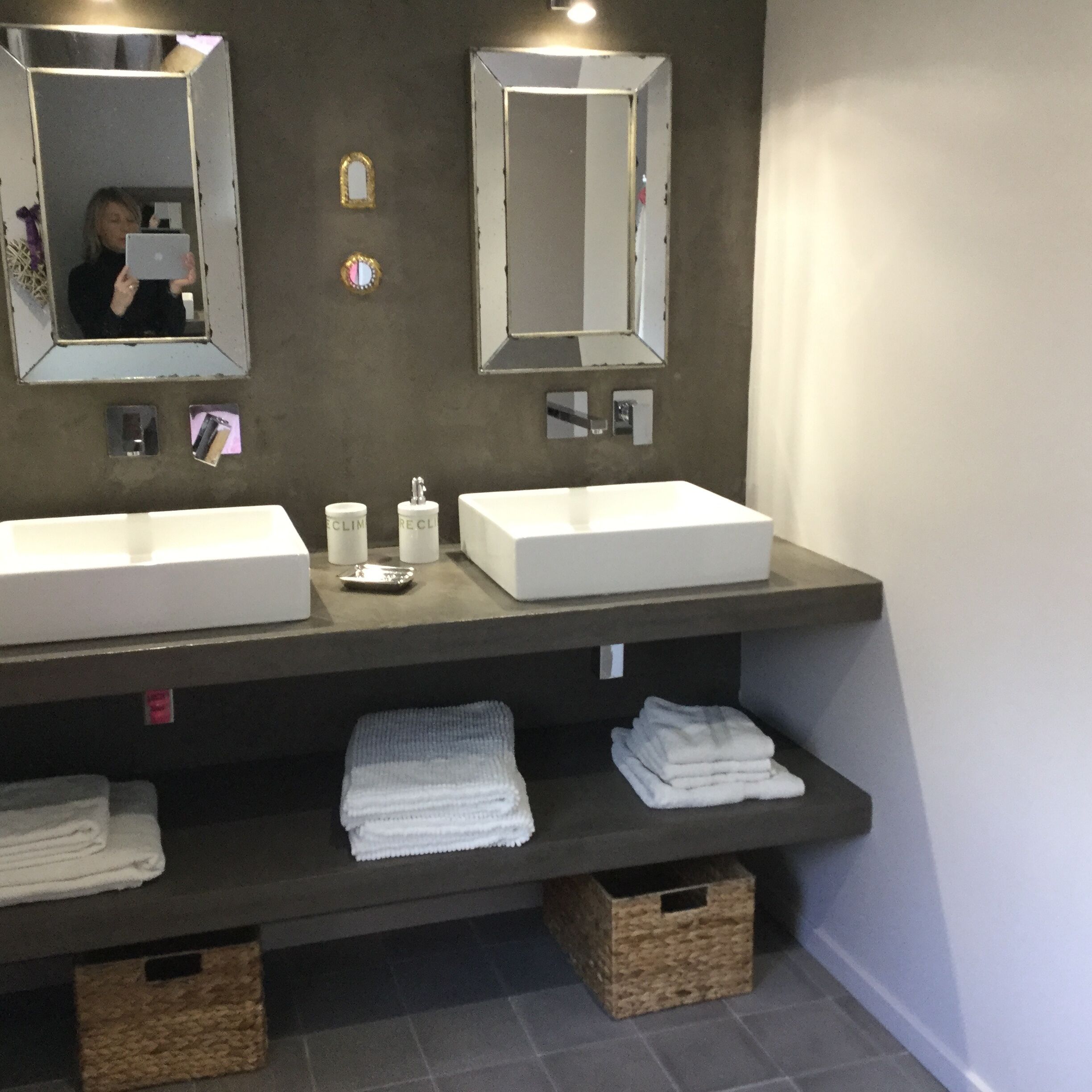 Een badkamer met twee wasbakken, een spiegel en een handdoekhouder.
