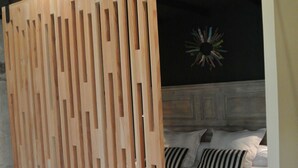 Un dormitorio con una cama, un panel de madera y un adorno de pared.