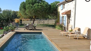 Una piscina al aire libre de temporada, sombrillas