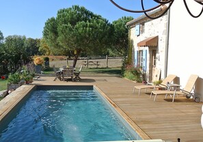 Een seizoensgebonden buitenzwembad en parasols bij het zwembad